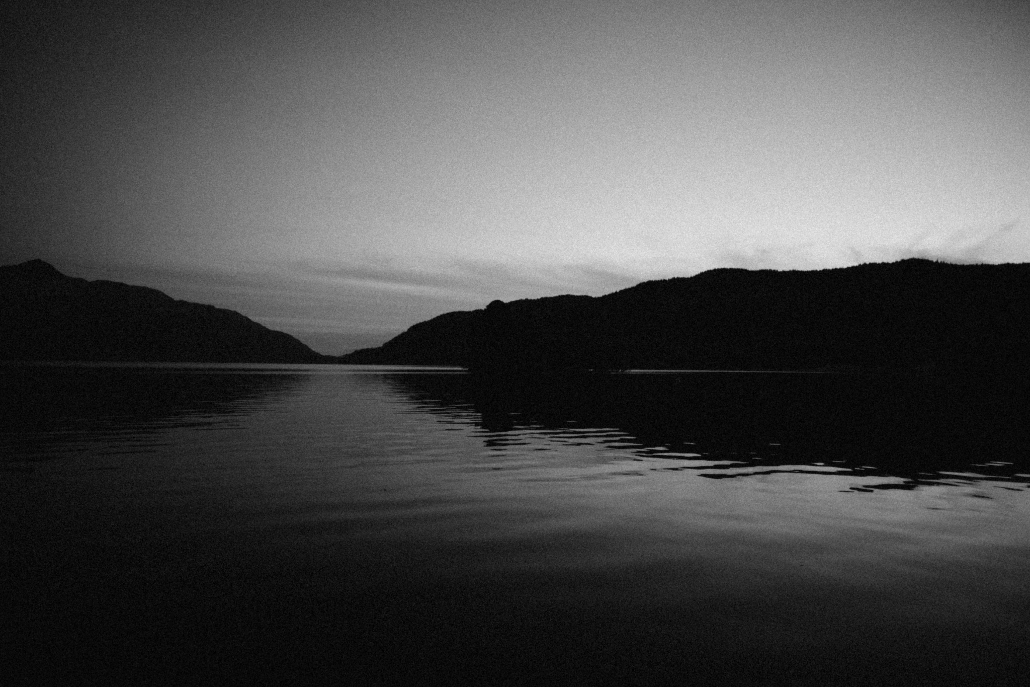 Still loch beneath a low, distant ridge