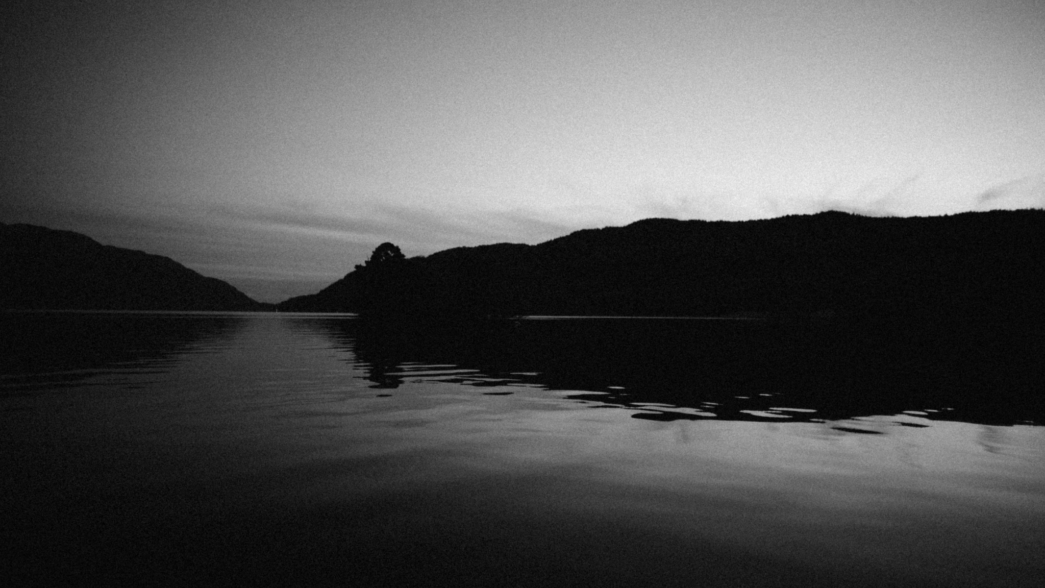 Loch water and the dark shoreline in the fading light